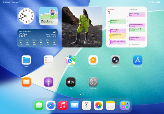 iPad, drie modellen, horizontale stand, het middelste model voor de twee andere, Apple Pencil magnetisch bevestigd aan de bovenkant van het middelste model, middelste scherm toont het Beginscherm met kleurrijke appsymbolen met Liquid Glass-effect, linkerscherm met Voorvertoning-app, rechterscherm met Beginscherm met bestanden die uitwaaieren vanuit het dock