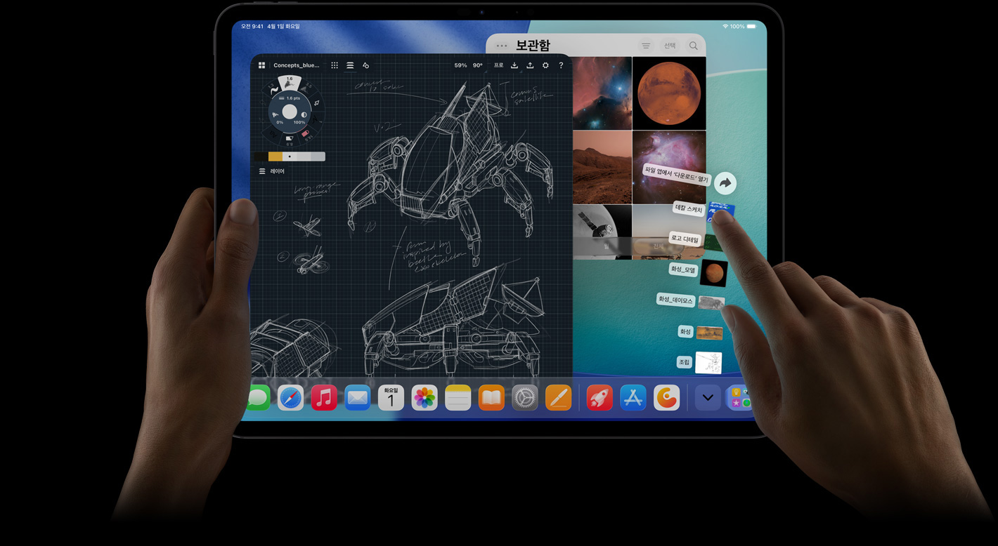 가로 방향으로 놓인 iPad Pro의 앞면 외관. 왼손은 기기를 들고 있고, 오른손은 다운로드 폴더의 부채처럼 펼쳐진 파일들을 가리키고 있습니다. 로봇 세부 설계도와 손글씨 주석, 여러 디자인 단계가 표시된 사진 편집 앱 등 여러 앱이 열려 있고 사진 보관함이 보이는 iPadOS 26 인터페이스가 화면에 표시되어 있습니다.