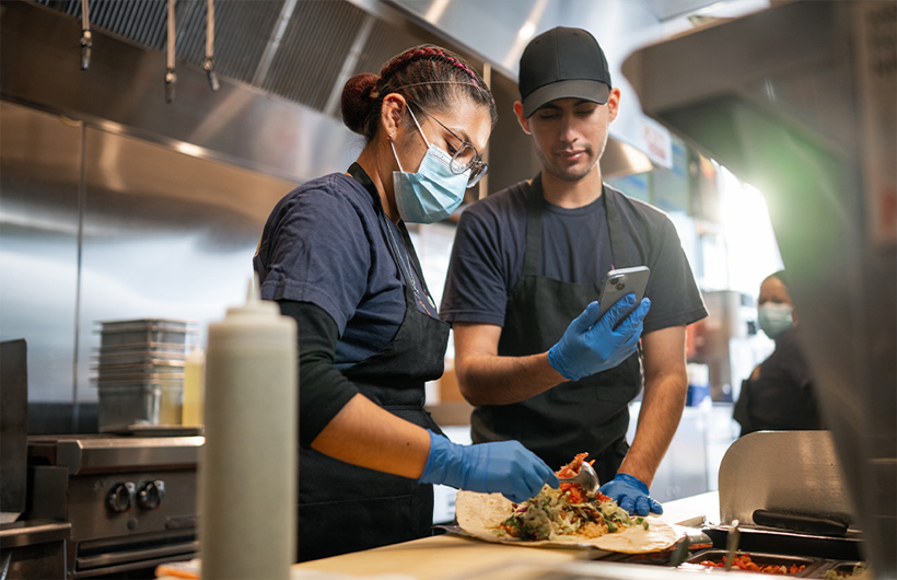 Eine Mitarbeiterin lernt, einen Burrito «nach Sisig-Art» zu rollen.